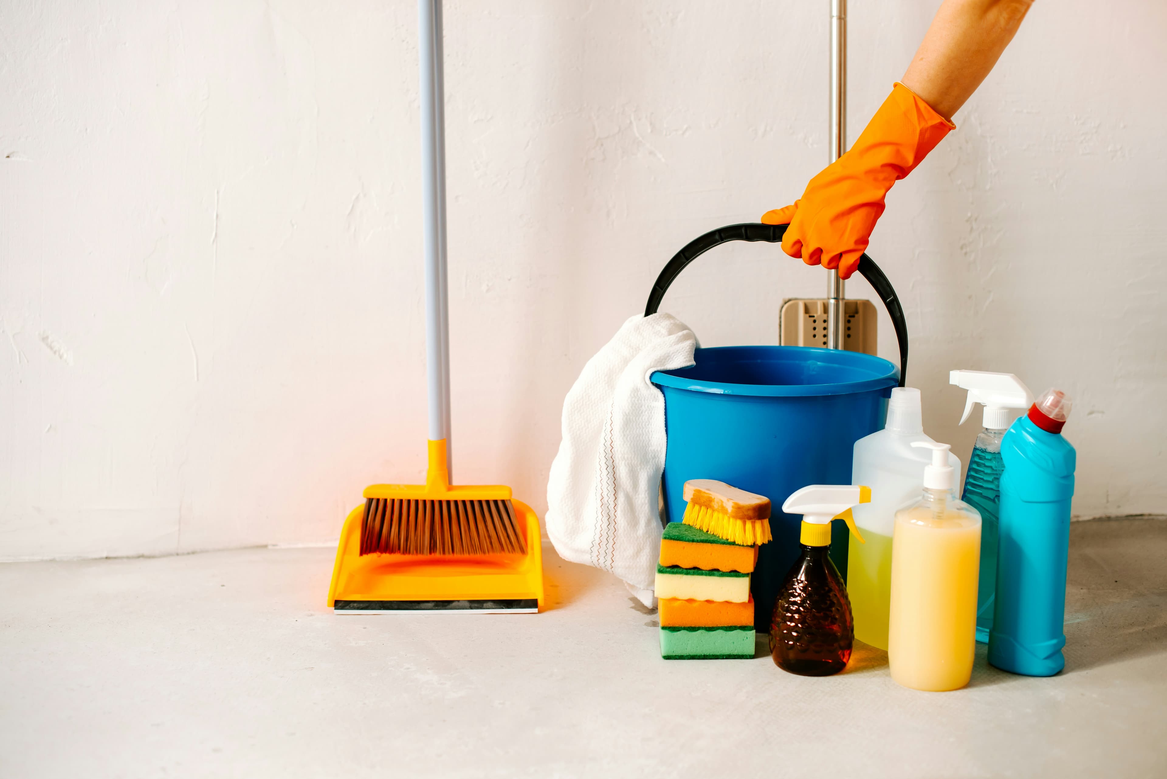 Professional cleaner cleaning sink with bright gloves and a sponge